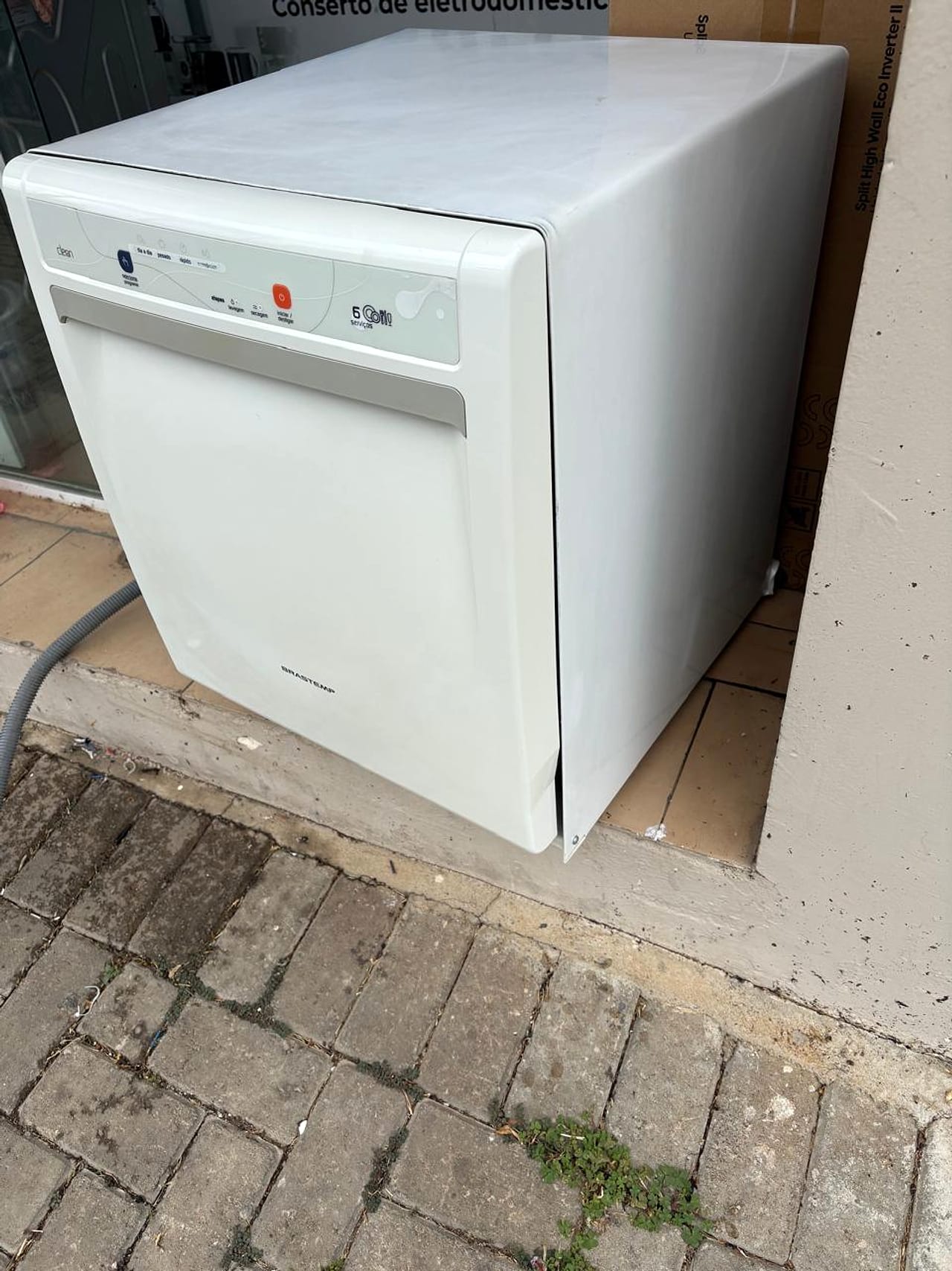 Geladeira Brastemp removida com placa de Conserto de Eletrodomésticos ao fundo